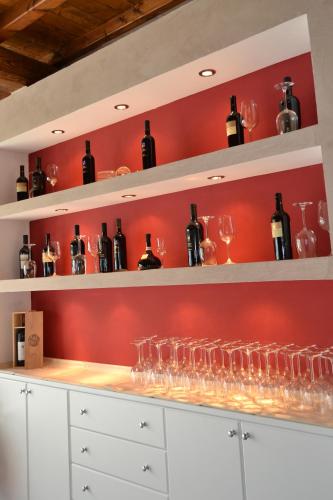 a wine cellar with wine glasses and red walls at Hotel Eremo in Soriano nel Cimino