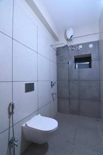 biała łazienka z toaletą i prysznicem w obiekcie N B Sonar Bangla Hotel w mieście Kalyani