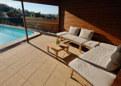 a patio with two couches and a swimming pool at Torre Costa Brava in Garrigás