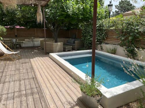 uma piscina num quintal com um deque de madeira em Maison Provençale à Eguilles em Éguilles