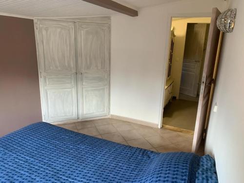 um quarto com uma cama azul e um espelho em MAISON AU COEUR DU VERDON em La Verdière