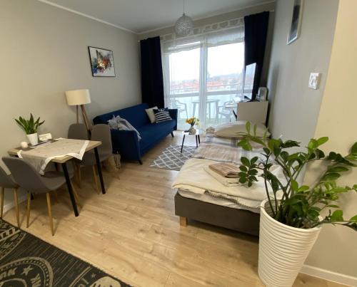a living room with a bed and a table at Apartament Mielczarskiego Tanie spanie Elbląg in Elblag