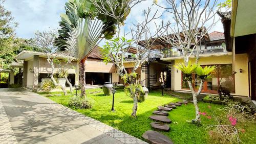 una casa con un patio con árboles y una acera en Villa Nirvana en Ubud