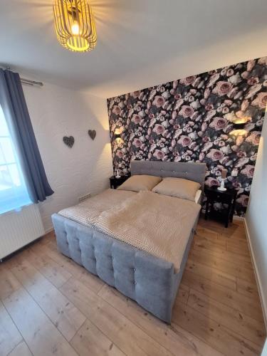 a bedroom with a large bed and a wall with logs at Zur alten Scheune in Ochtendung