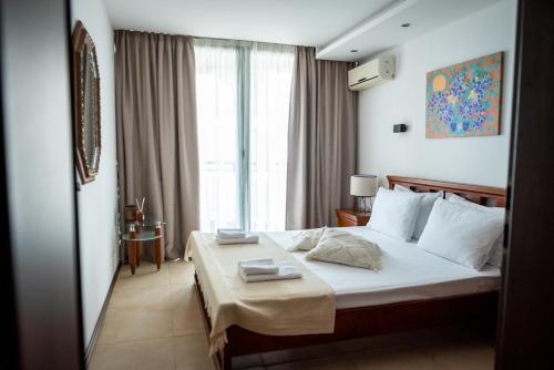 a hotel room with a bed with towels on it at Port Balchik apartment in Balchik