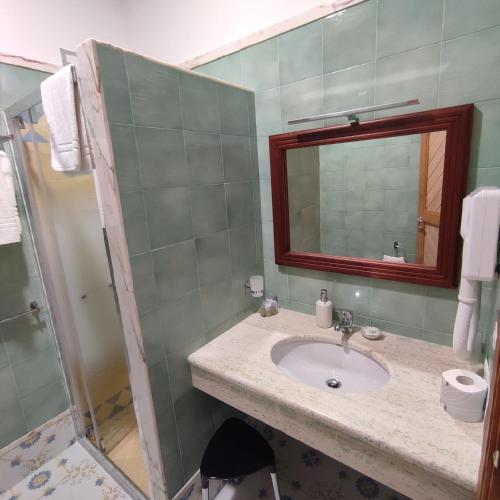a bathroom with a sink and a shower with a mirror at Il Barbacane in Bacoli