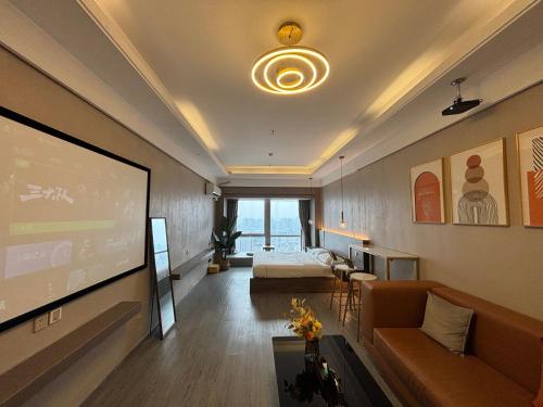 a living room with a projection screen and a bed at Guangzhou City Inn Hotel Apartment Changgang in Guangzhou