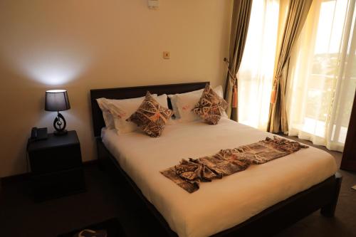 a bed with pillows on it in a bedroom at Precious Villas Lubowa in Kampala
