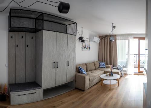 a living room with a couch and a large entertainment center at Queen's Garden Balchik apartment in Balchik