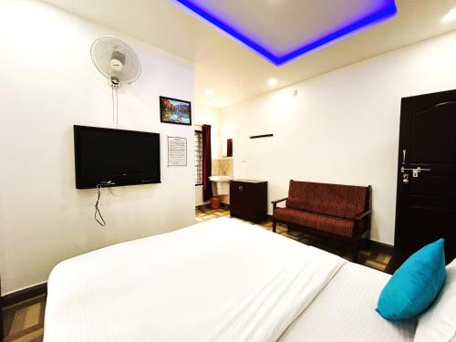 Cette chambre comprend un lit et une télévision. dans l'établissement Deluxe Residency, à Kalpatta
