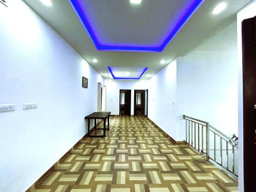 a hallway with a blue light on the ceiling at Deluxe Residency in Kalpetta