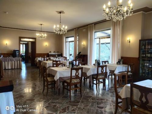 un comedor con mesas, sillas y lámparas de araña en Hotel Garden, en Torri del Benaco