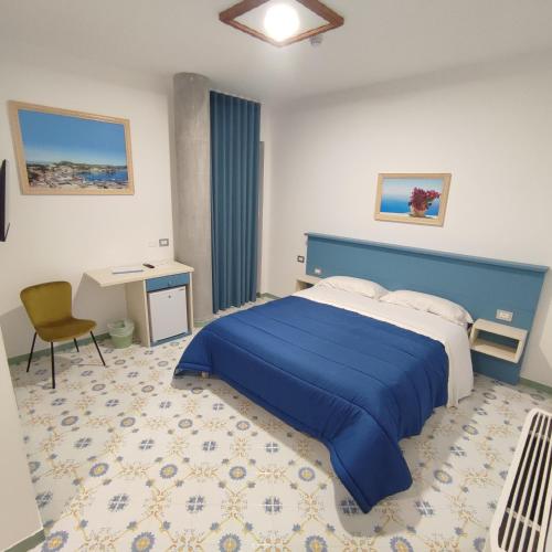 Schlafzimmer mit einem blauen Bett und einem Schreibtisch in der Unterkunft Il Barbacane in Bacoli