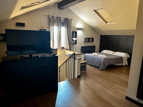 a bedroom with a bed and a flat screen tv at Borgo Manzoni - Charming House in Rozzano