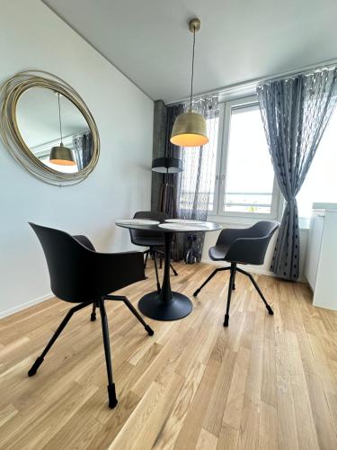 a living room with a table and chairs and a mirror at MydiHei @ Rhyfall Towers in Neuhausen am Rheinfall