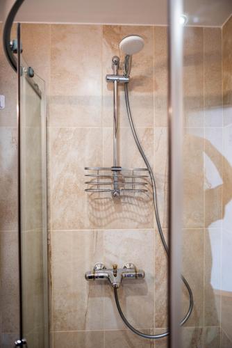 a shower with a shower head in a bathroom at Queen's Palace Balchik apartment in Balchik