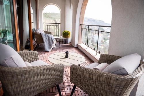 Habitación con sillas, mesa y ventanas. en Queen's Palace Balchik apartment en Balchik