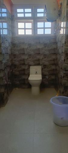 a bathroom with a toilet and a bath tub at ND HOMESTAY in Tawang