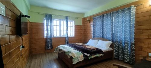 a bedroom with a bed and a window at ND HOMESTAY in Tawang