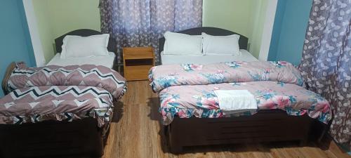 2 Betten in einem Zimmer mit 2 in der Unterkunft ND HOMESTAY in Tawang