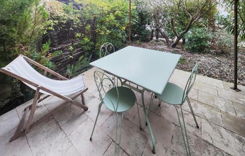 - une table blanche et 2 chaises sur la terrasse dans l'établissement Lovely Home, à Saint-Laurent-de-la-Cabrerisse