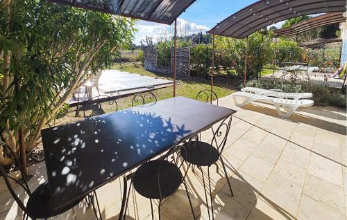 a table sitting on a patio under an umbrella at Stunning Home In Saint-Laurent-De-La-Ca in Saint-Laurent-de-la-Cabrerisse