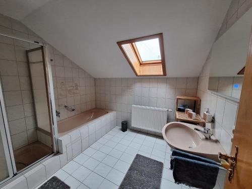 een badkamer met een bad, een wastafel en een douche bij Ferienwohnung-Felisa in Peterswörth