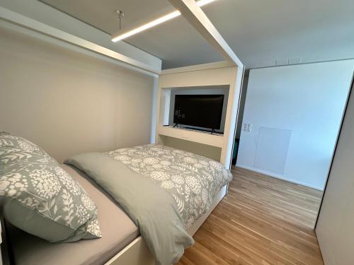 a small bedroom with a bed and a flat screen tv at MydiHei @ Rhyfall Towers in Neuhausen am Rheinfall