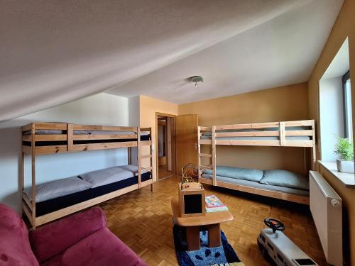 a living room with bunk beds and a purple couch at Ferienwohnung-Felisa in Peterswörth