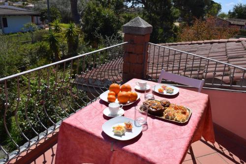 une table avec des assiettes de nourriture sur un tissu de table rose dans l'établissement Arbatax, 200 metres from the beach: Apartment in villa with garden, 2 bedrooms, à Àrbatax