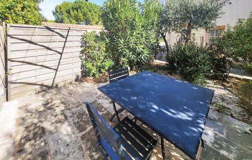 a blue table and a bench in a backyard at Lovely Home In Saint-Laurent-De-La-Ca in Saint-Laurent-de-la-Cabrerisse