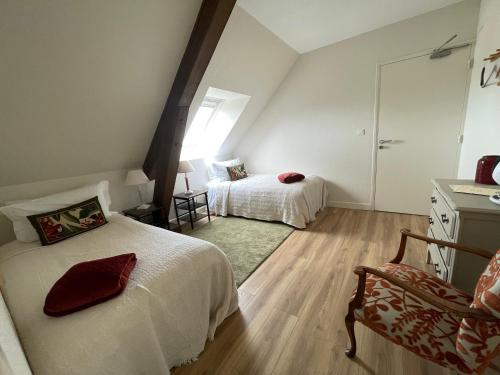 - une chambre avec deux lits, une chaise et un miroir dans l'établissement Fonsegre Chambres d'Hôtes, à Magny-Cours