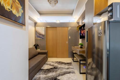 a living room with a couch and a refrigerator at Lush Residences Makati in Manila