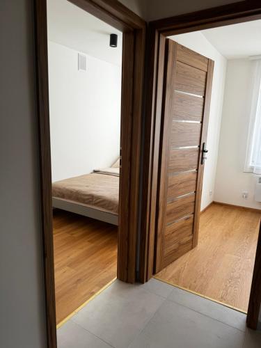 uma porta que leva a um quarto com uma cama em Apartament na Orkana em Rabka-Zdroj