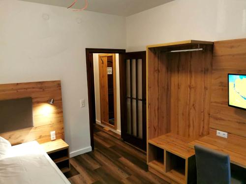 a room with a bed and a tv and a desk at Heidehotel Soltauer Hof in Soltau