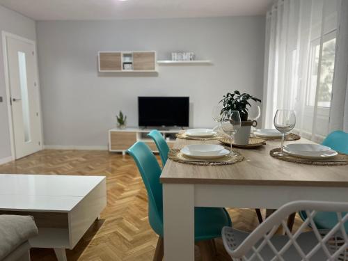 a dining room with a table and blue chairs at VuT Las Almenas in Avila