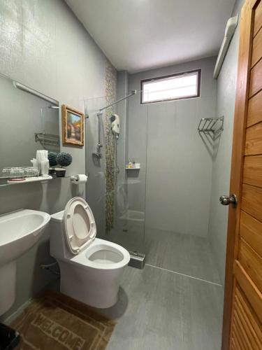 uma casa de banho com um WC, um chuveiro e um lavatório. em โมเมนต์ แอ๊ท ริมโขง em Chiang Khan