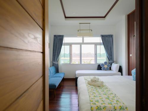 um quarto de hotel com duas camas e uma janela em โมเมนต์ แอ๊ท ริมโขง em Chiang Khan
