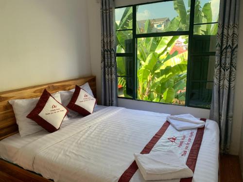 sypialnia z łóżkiem i dużym oknem w obiekcie Vang Vieng Lily Guesthouse w mieście Vang Vieng