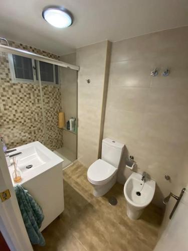 a bathroom with a white toilet and a sink at Playa Rompido in Huelva
