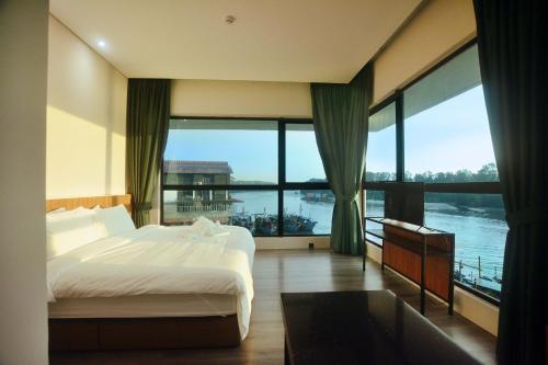Habitación de hotel con cama y ventana grande en Crosview, en Kampung Sepetang