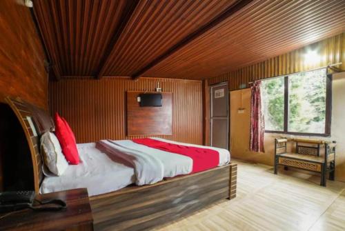 a bedroom with a large bed with red pillows at Goroomgo Long View Retreat Nainital in Nainital