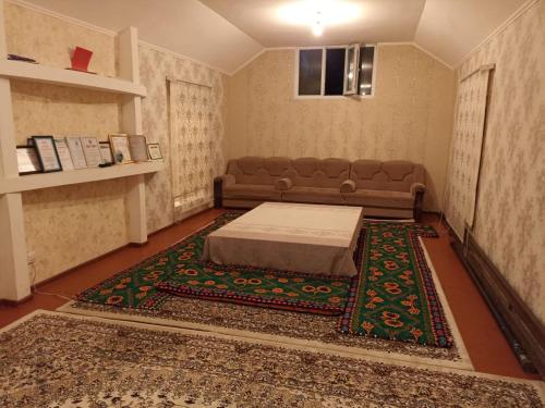 sala de estar con sofá y alfombra en Talgat & Kaabal, en Kara-Agach
