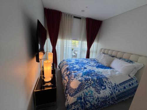 a bedroom with a blue and white bed and a window at Luxury accommodation in Sydney