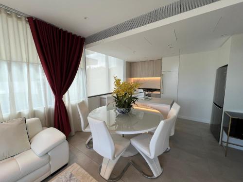 Luxury accommodation في سيدني: غرفة طعام مع طاولة وكراسي بيضاء