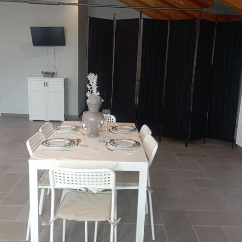 a white table with plates and a vase on it at Appartamento Ca' Mia in Cisterna dʼAsti