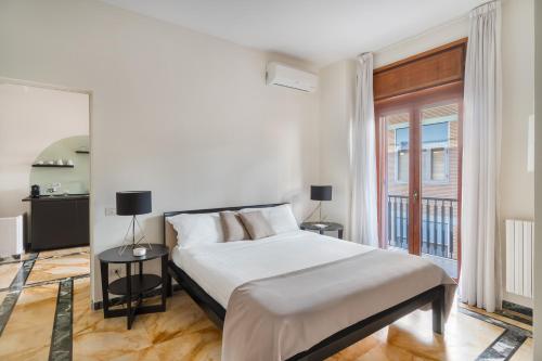 - une chambre blanche avec un grand lit et une fenêtre dans l'établissement Starhost - GOLDEN SUITE, à Salerne