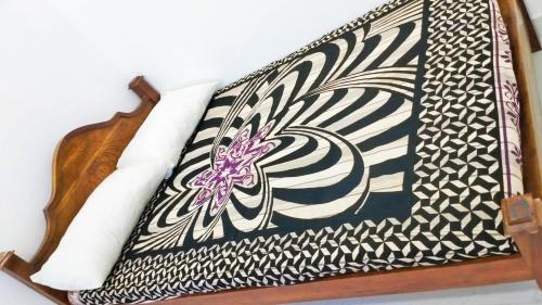 a black and white bag on a wooden shelf at Rooms Trincomalee Low Price in Trincomalee