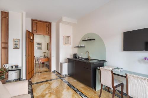 una cucina con lavandino e tavolo in una stanza di Starhost - GOLDEN SUITE a Salerno