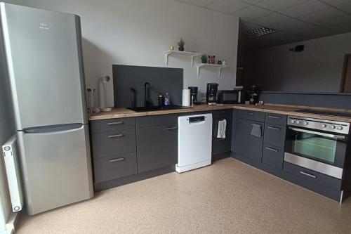 a kitchen with gray cabinets and a white refrigerator at FEWO an der ZWÄNS in Stollberg